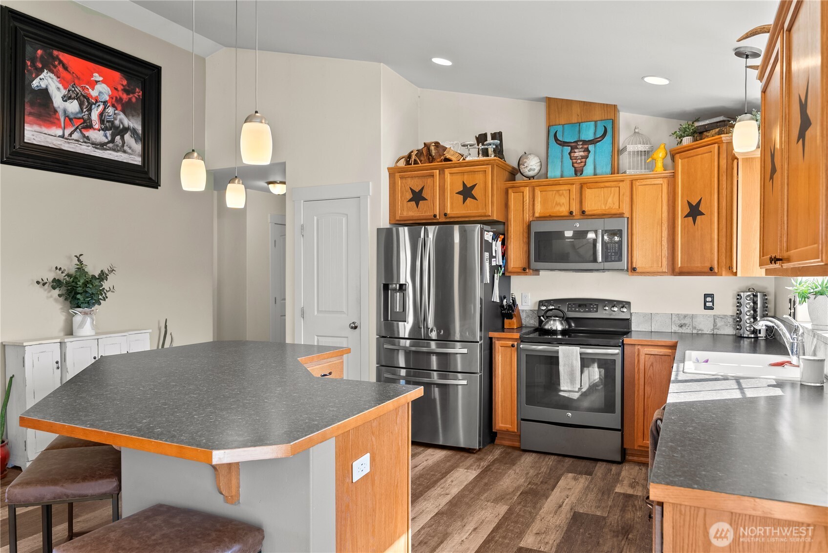 1486 North Star Road Malott, WA 98829 - Photo 12 of 40 a kitchen with stainless steel appliances granite countertop a stove a refrigerator a sink a dining table and chairs with wooden floor