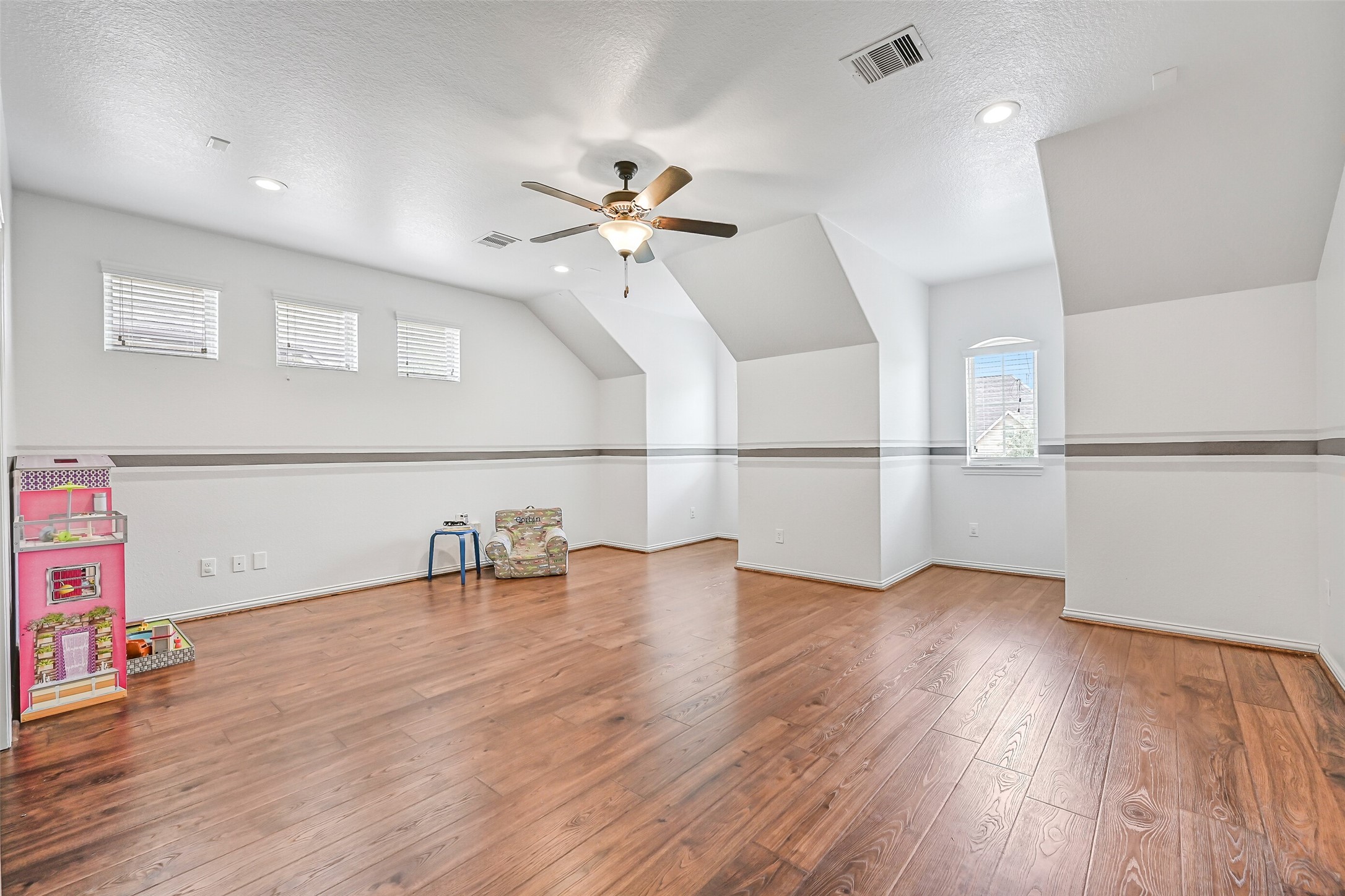 1008 Point Isabel Lane Friendswood, TX 77546 - Photo 36 of 50 An expansive upstairs gameroom with wood flooring provides incredible flexibility for entertaining, play, or media use, enhanced by recessed lighting, surround sound wiring, and multiple windows for natural light.