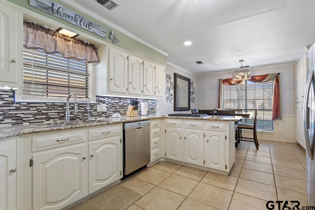 6005 Raleigh Drive Tyler, TX 75703 - Photo 11 of 35 a kitchen with granite countertop white cabinets white appliances with a sink and dishwasher