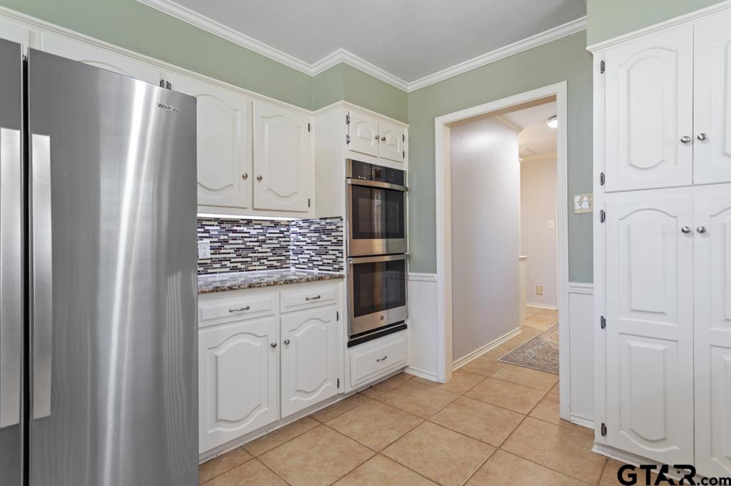 6005 Raleigh Drive Tyler, TX 75703 - Photo 13 of 35 a kitchen with white cabinets and refrigerator