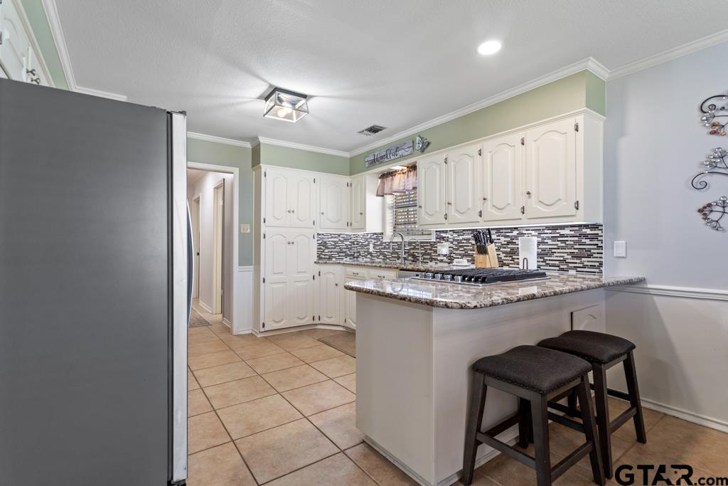 6005 Raleigh Drive Tyler, TX 75703 - Photo 14 of 35 a kitchen with stainless steel appliances granite countertop a stove a sink and a refrigerator