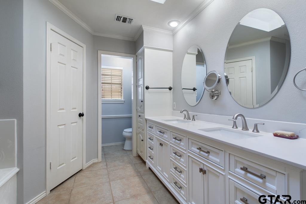 6005 Raleigh Drive Tyler, TX 75703 - Photo 19 of 35 a en suite bathroom with double sink and a mirror