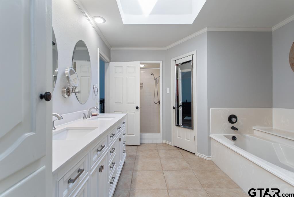 6005 Raleigh Drive Tyler, TX 75703 - Photo 20 of 35 a spacious bathroom with a tub sink and mirror