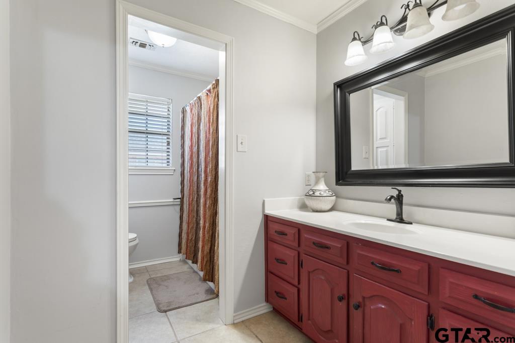 6005 Raleigh Drive Tyler, TX 75703 - Photo 22 of 35 a bathroom with a double vanity sink and a mirror