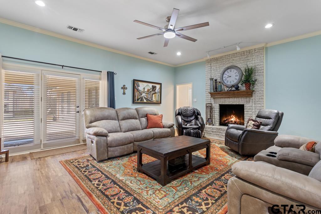 6005 Raleigh Drive Tyler, TX 75703 - Photo 7 of 35 a living room with furniture a fireplace and a floor to ceiling window