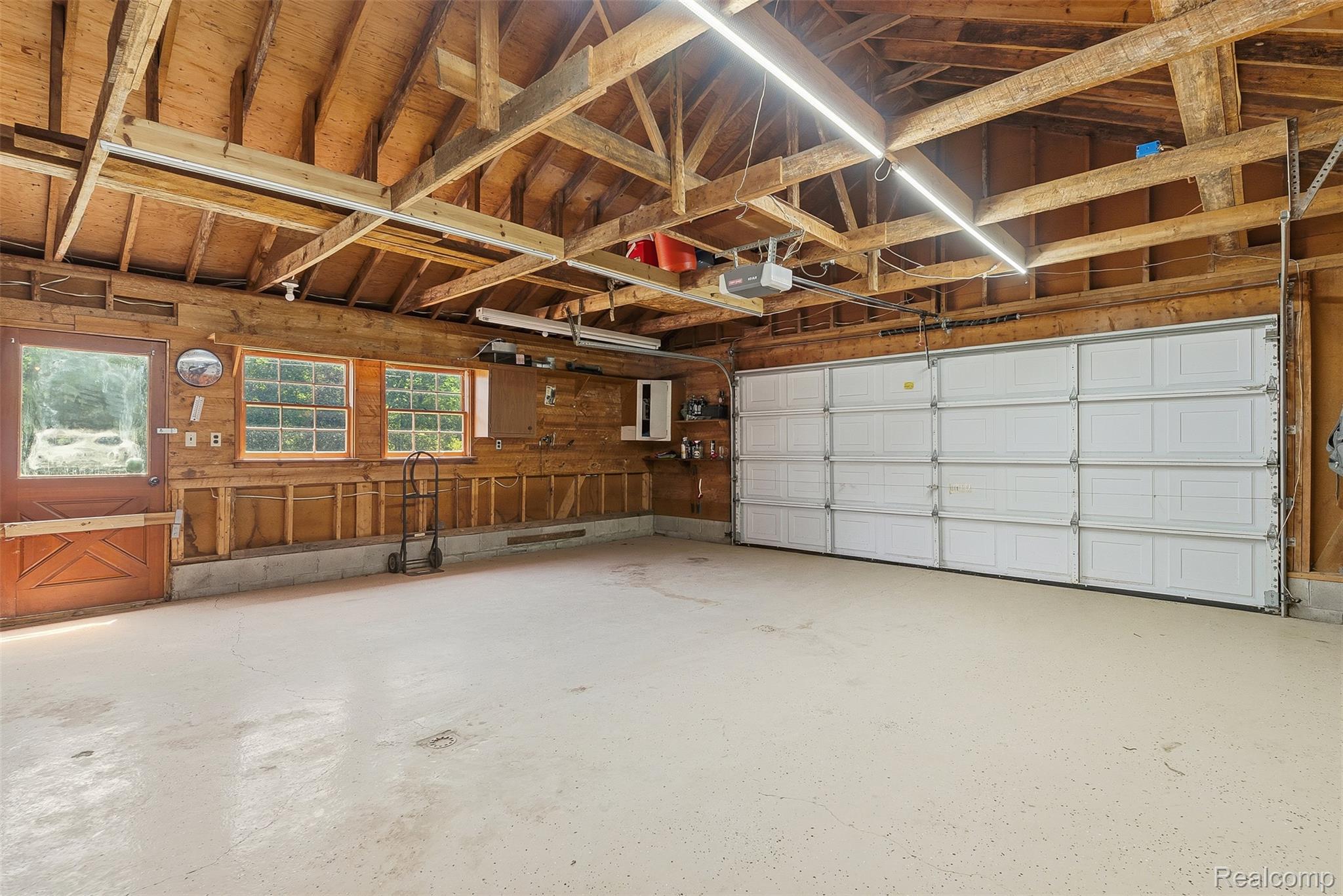 3656 Stanley Road Columbiaville, MI 48421 - Photo 36 of 65 Spacious garage featuring exposed wood beam ceilings and a large white overhead door
