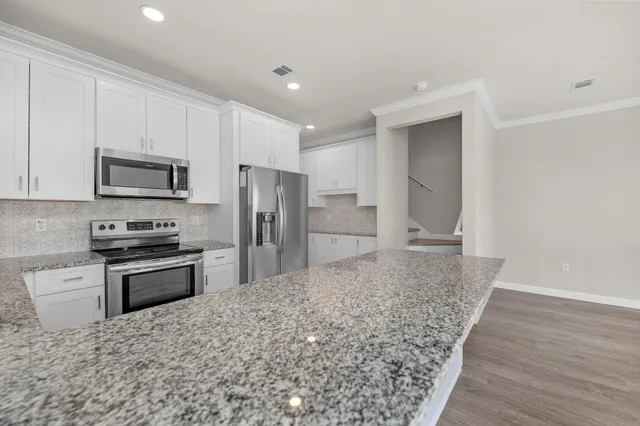 a kitchen with stainless steel appliances granite countertop a stove a sink and a refrigerator