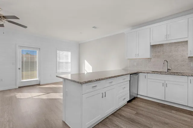 a kitchen with granite countertop white cabinets and a sink