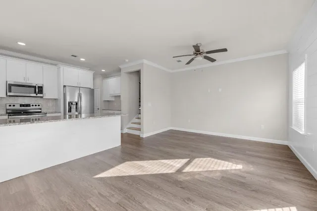 a view of a hallway with wooden floor and entryway