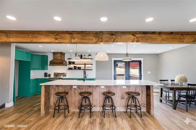 a large white kitchen with a large island oven a stove and a sink
