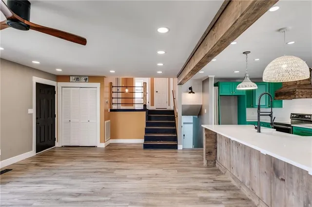 a kitchen with stainless steel appliances granite countertop a large kitchen island a stove and a refrigerator