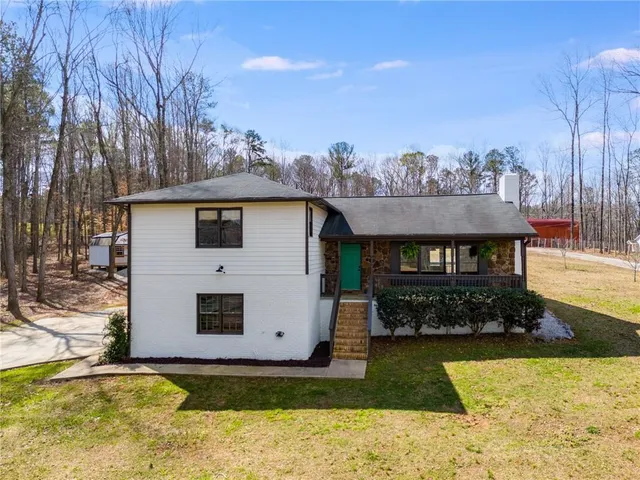 a view of a house with backyard and sitting area