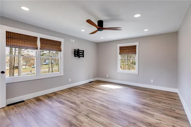 an empty room with a window and ceiling fan