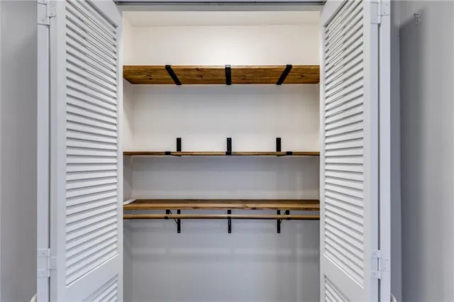 a view of walk in closet with clothes and shoes