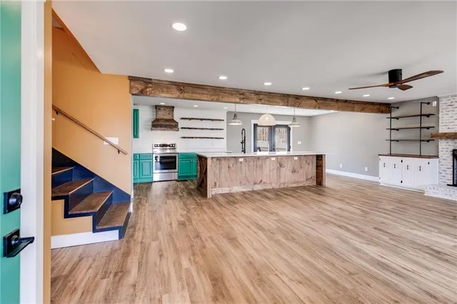 a large living room with a fireplace and a ceiling fan