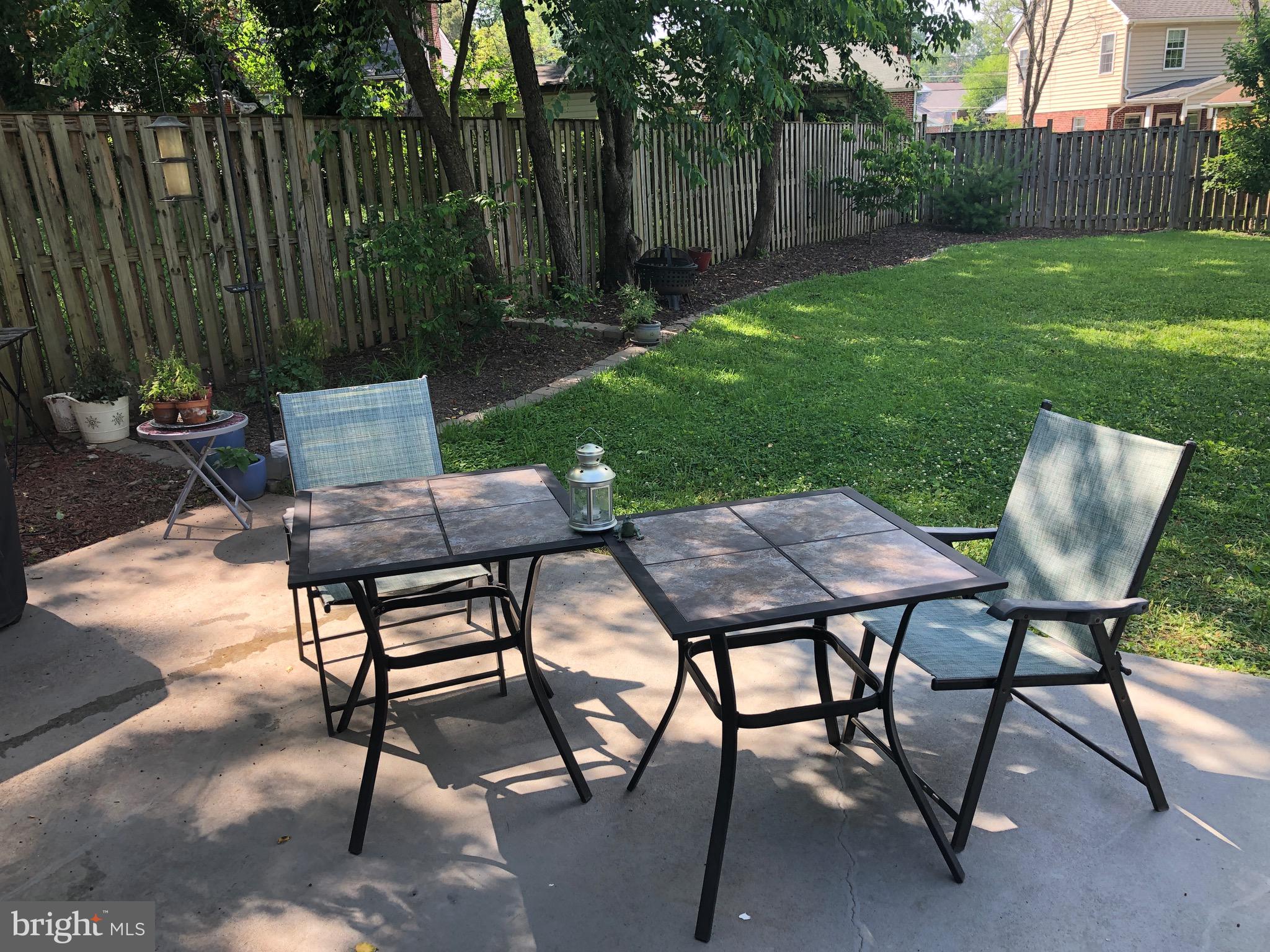 1403 Gleason Street Silver Spring, MD 20902 - Photo 12 of 34 a view of a backyard with table and chairs with wooden fence and plants