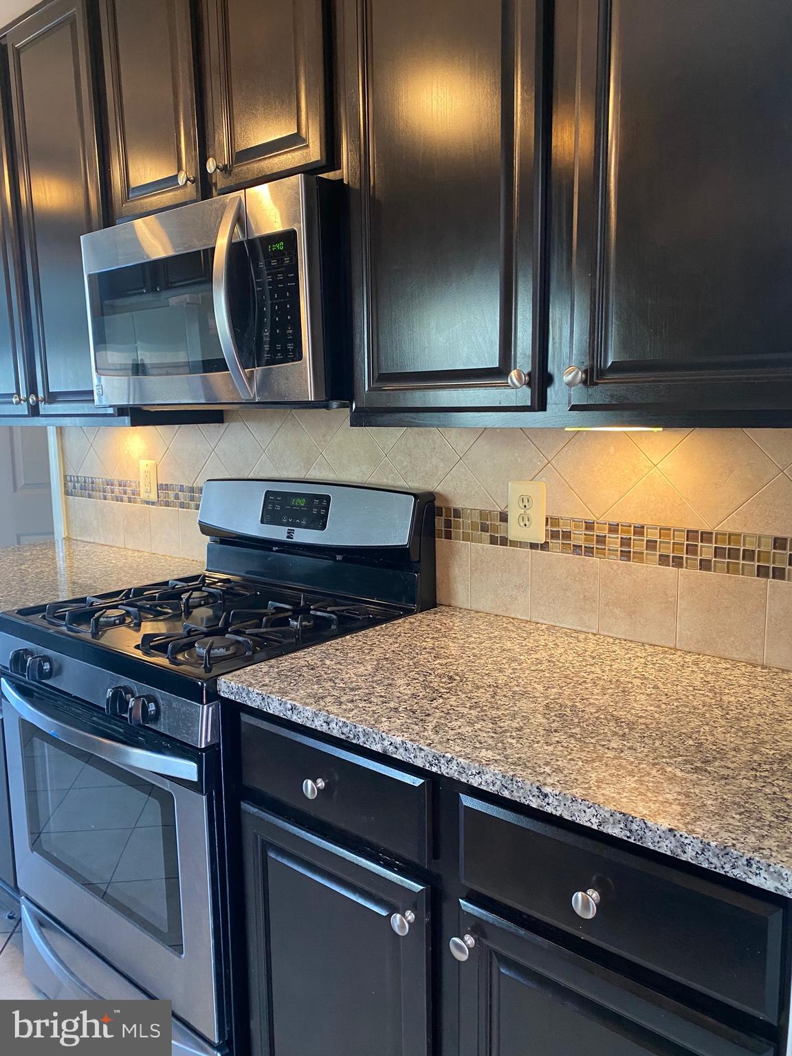 1403 Gleason Street Silver Spring, MD 20902 - Photo 18 of 34 a kitchen with granite countertop a stove and a sink