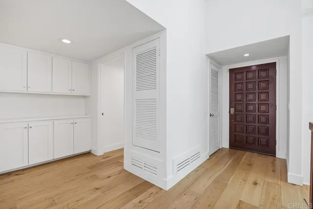 a view of empty room with wooden floor and cabinet