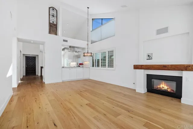 a view of an empty room with a fireplace and a window