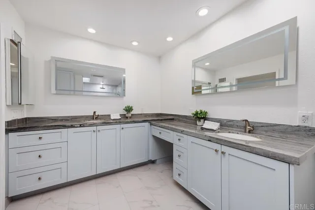 a kitchen with granite countertop a sink and white cabinets