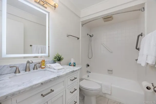a bathroom with a granite countertop sink a toilet and shower