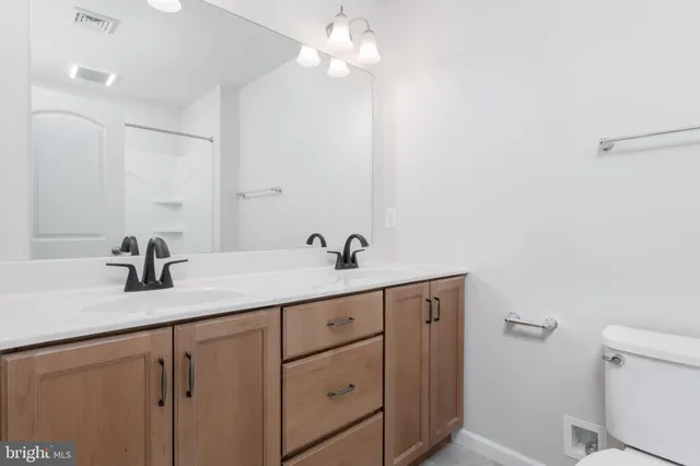 a bathroom with a granite countertop sink a toilet and mirror
