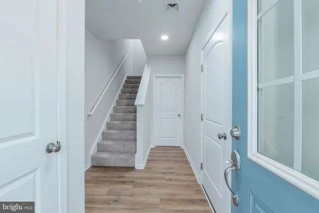 a view of a hallway with wooden floor and entryway