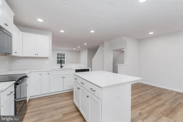 a kitchen with white cabinets appliances and sink
