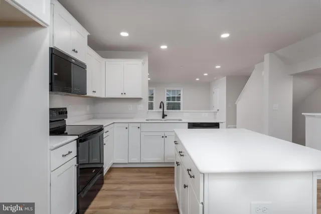 a kitchen with white cabinets appliances and sink
