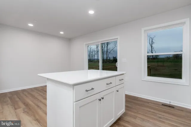 an empty room with wooden floor and window
