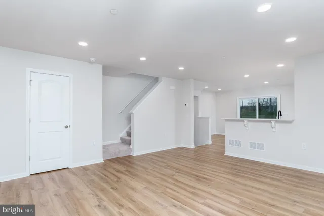 a view of empty room with wooden floor and window