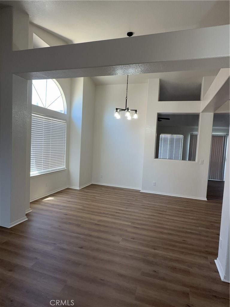 12590 Cobalt Road Victorville, CA 92392 - Photo 13 of 37 an empty room with wooden floor cabinet and windows