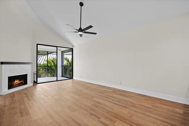 a view of empty room with wooden floor fireplace and a window