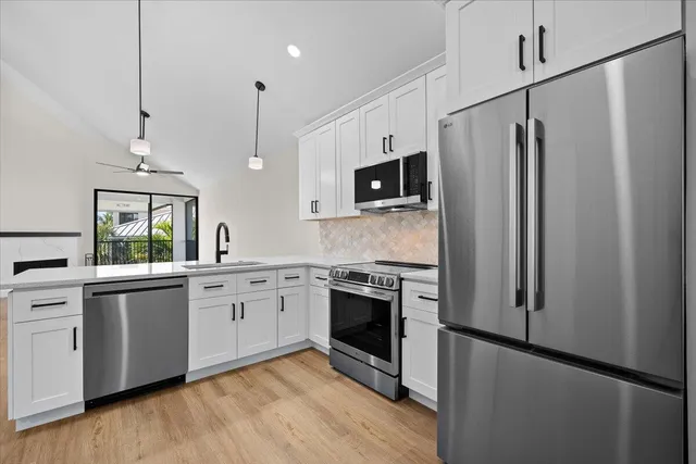 a kitchen with stainless steel appliances granite countertop a refrigerator a stove a sink and a microwave