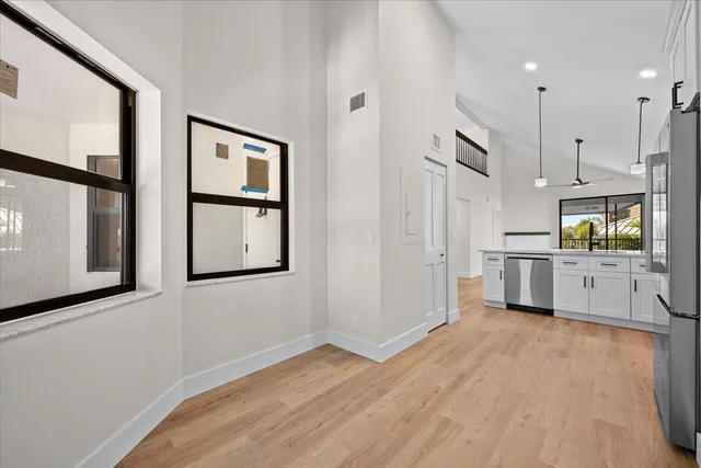 a view of a kitchen with wooden floor and electronic appliances