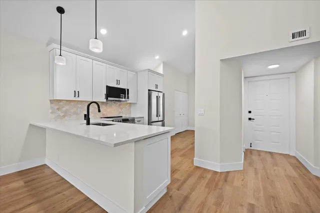 a kitchen with stainless steel appliances granite countertop a sink stove and refrigerator