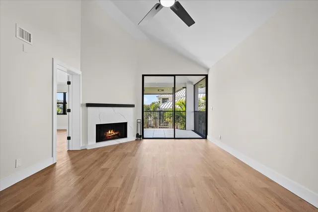 an empty room with fireplace wooden floor and windows