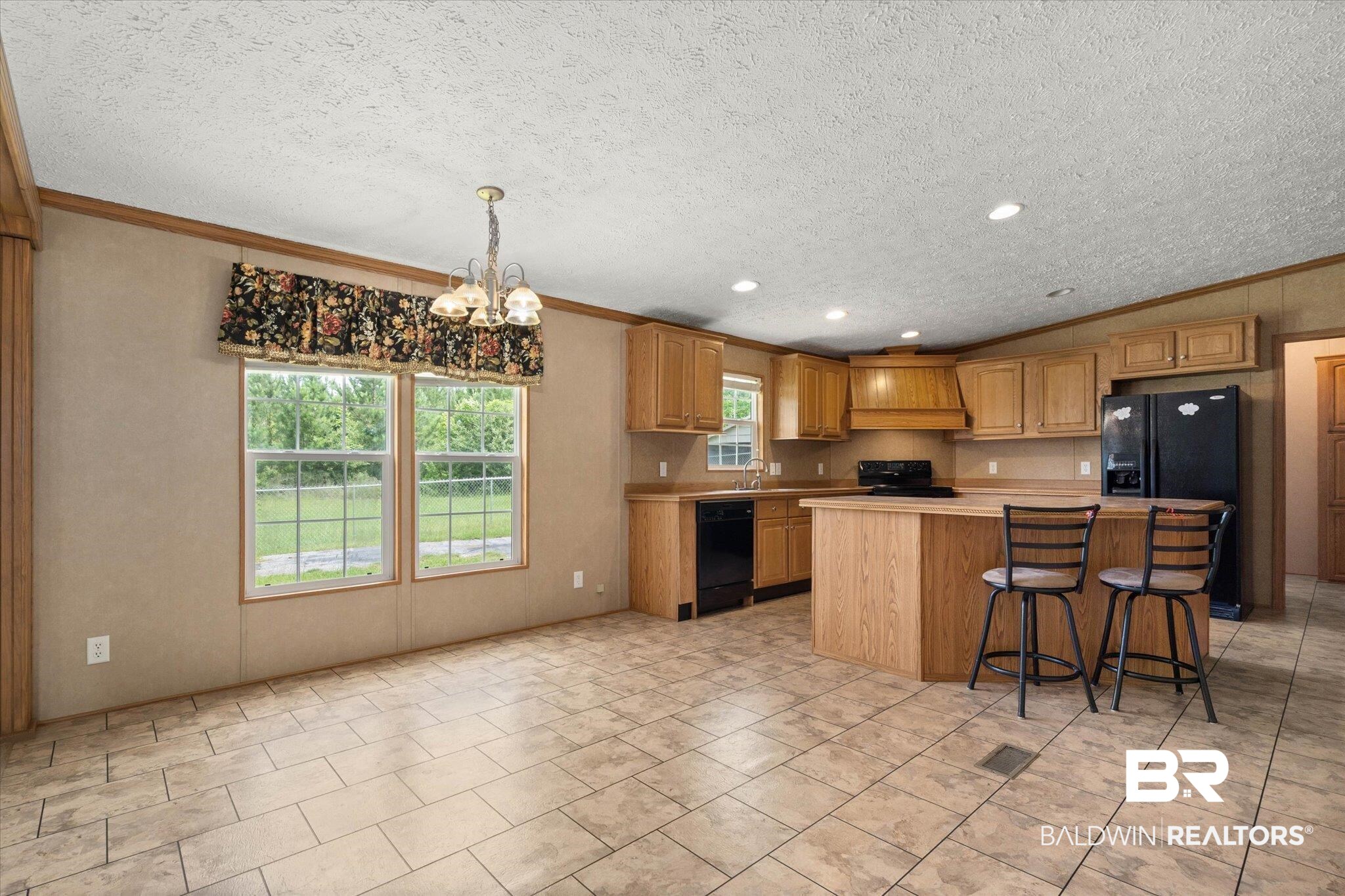 9335 Nathan Jordan Road Millry, AL 36558 - Photo 8 of 20 Kitchen featuring black appliances, light countertops, crown molding, a textured ceiling, and a chandelier