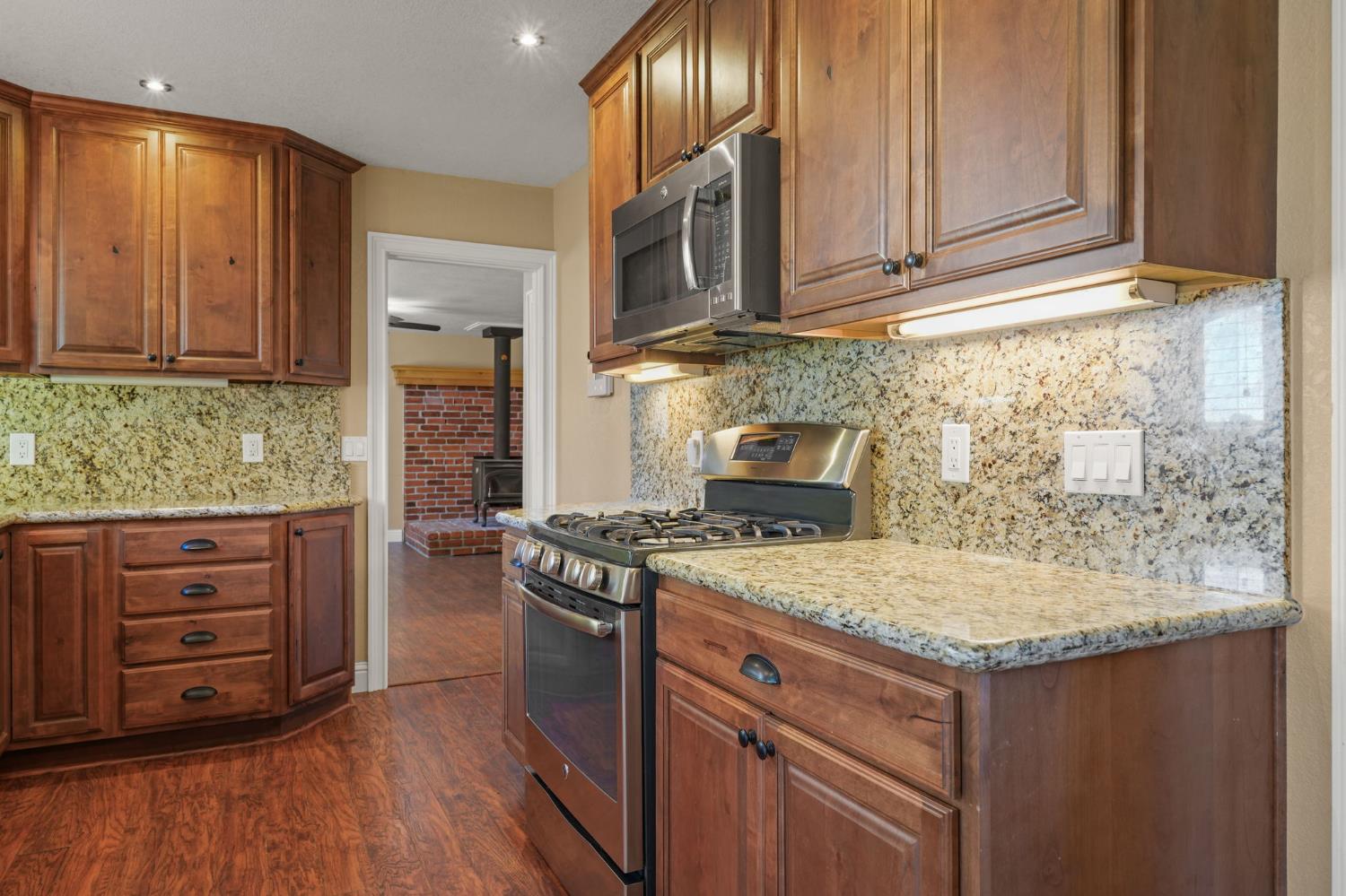 24980 North Canyon Way Colfax, CA 95713 - Photo 12 of 30 a kitchen with granite countertop wooden cabinets and a stove