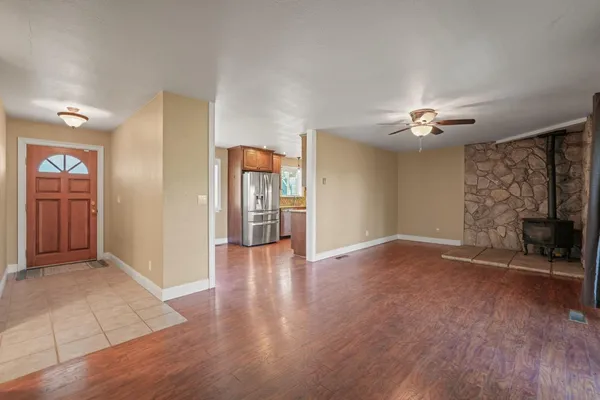 a view of an empty room with window and a ceiling fan