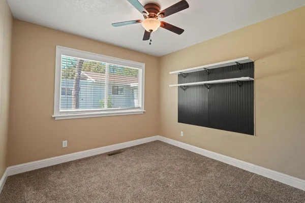 a view of an empty room with a ceiling fan