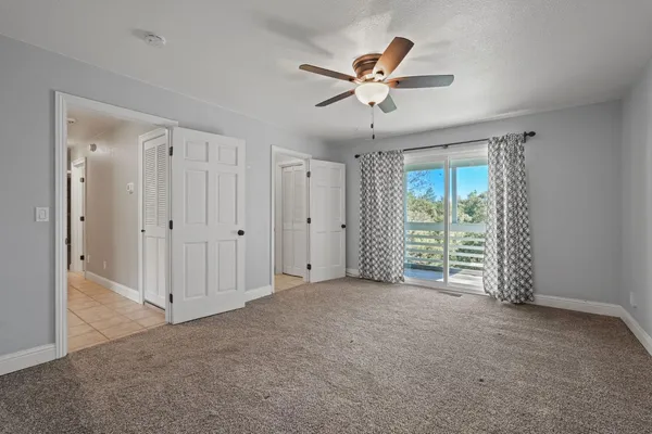 a view of a livingroom with a ceiling fan & entryway