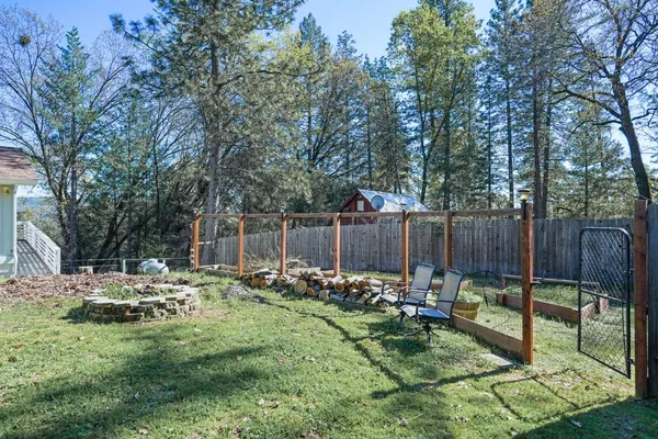 a view of backyard with wooden fence and trees