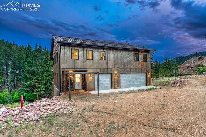 View of front of house featuring dirt driveway and a garage