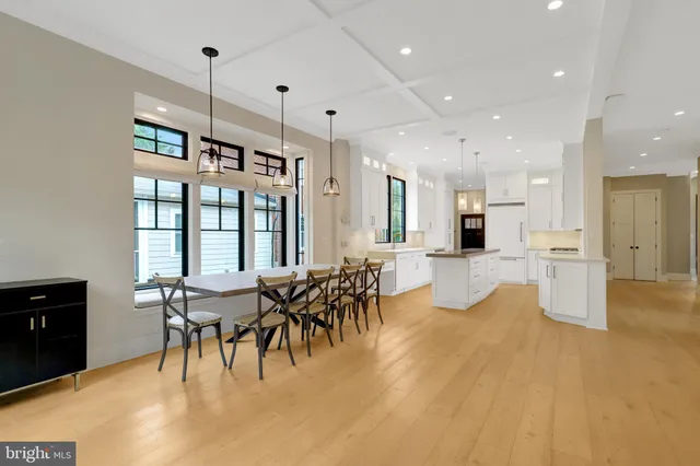 a view of a dining room and livingroom with furniture wooden floor a chandelier
