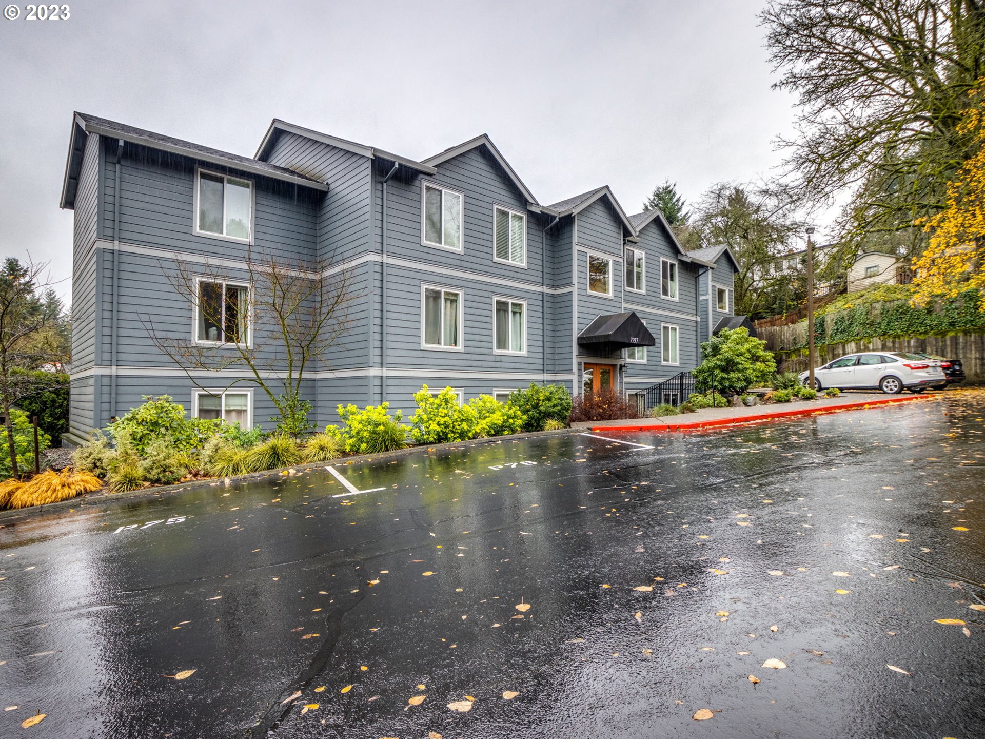 7937 Southwest 40th Avenue, Unit F Portland, OR 97219 - Photo 2 of 36 a front view of a house with a yard