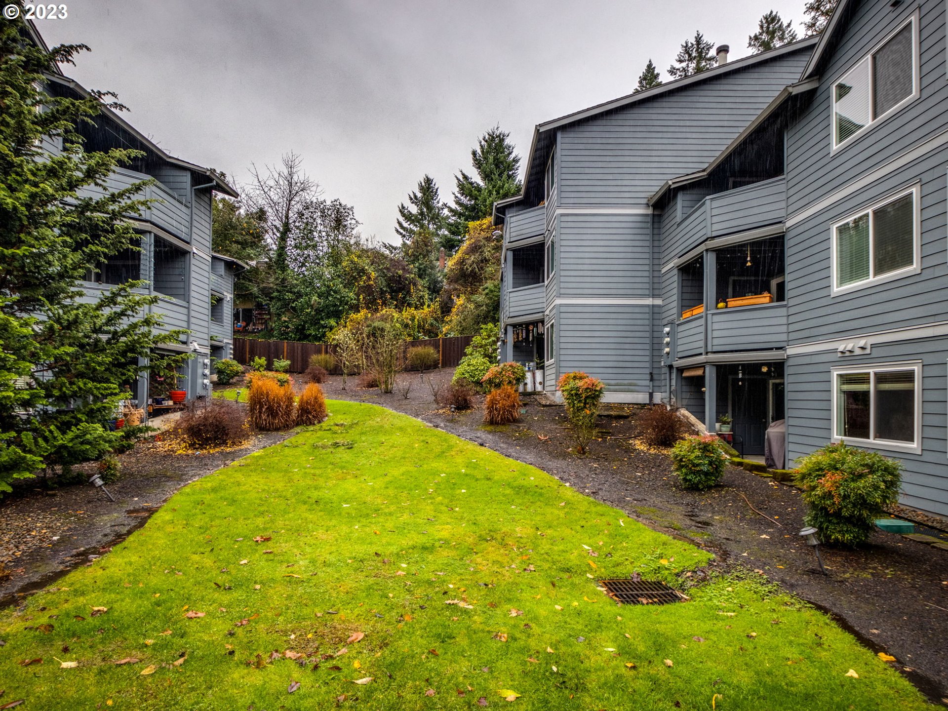 7937 Southwest 40th Avenue, Unit F Portland, OR 97219 - Photo 25 of 36 a view of a backyard with plants and a patio