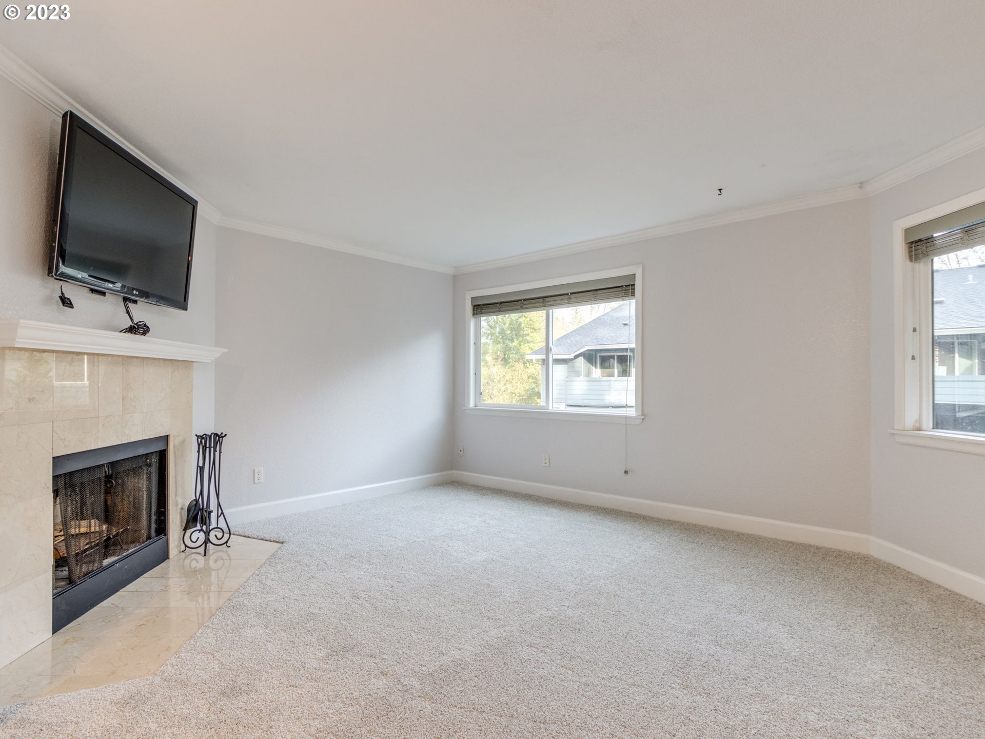 7937 Southwest 40th Avenue, Unit F Portland, OR 97219 - Photo 3 of 36 an empty room with a fireplace and windows