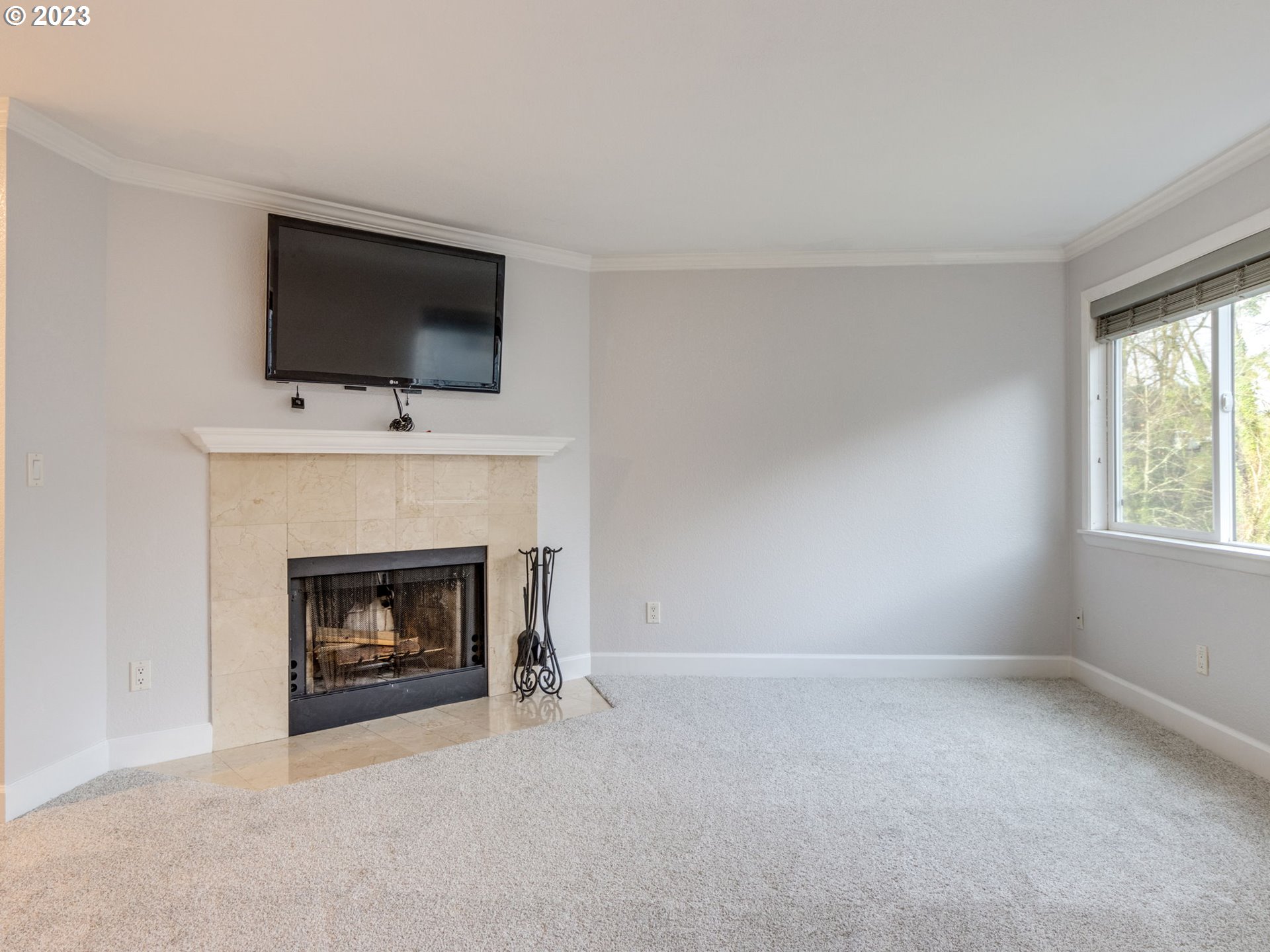 7937 Southwest 40th Avenue, Unit F Portland, OR 97219 - Photo 4 of 36 a living room with a fireplace and a flat screen tv