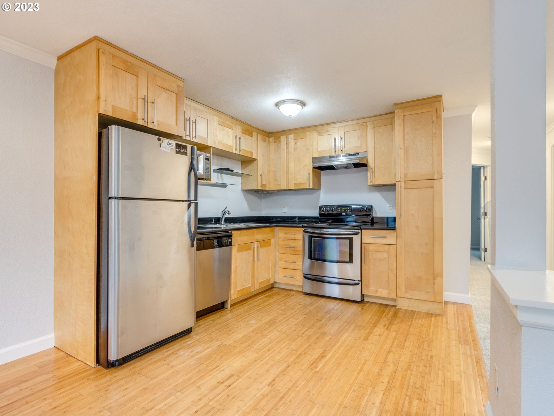 7937 Southwest 40th Avenue, Unit F Portland, OR 97219 - Photo 8 of 36 a kitchen with a refrigerator and a stove top oven